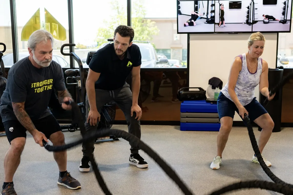 Members work through battle rope intervals during a coached session at an Alloy Personal Training studio